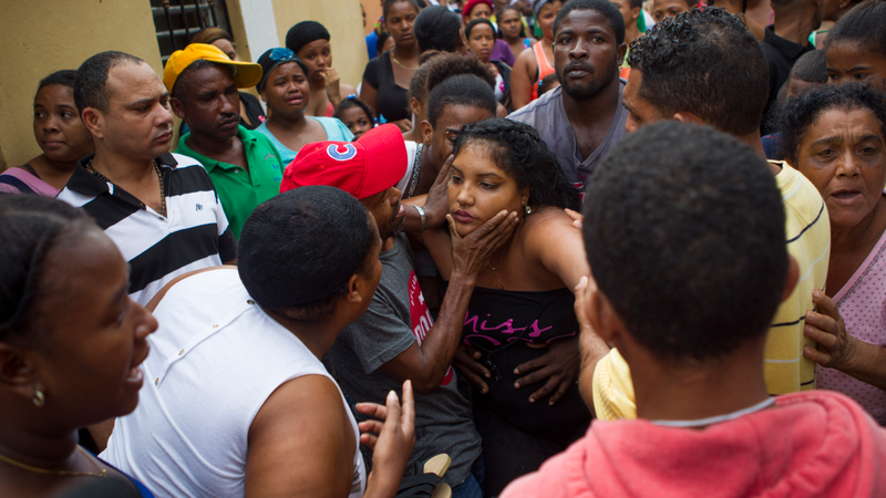 The mother (C) of two girls who died when a landslide knocked the walls of their house down during the passage of Hurricane Matthew, is comforted outside her house in the neighbourhood of Capotillo, in Santo Domingo on October 4, 2016. Matthew, a Category Four hurricane, slammed into the Dominican Republic and Haiti Tuesday, triggering major floods and forcing thousands to flee the path of the storm that has claimed at least three lives in each country. (Image: Getty)